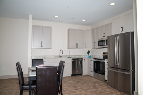 A kitchen with a table and chairs.