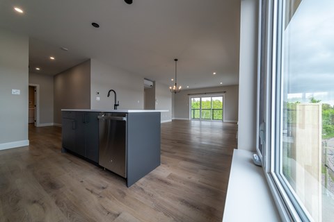 A modern kitchen with a large island and wooden floors.