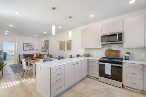 A kitchen with white cabinets and a microwave above the stove.