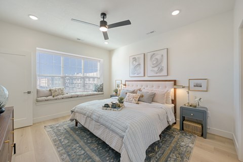 A bedroom with a large bed and a ceiling fan.
