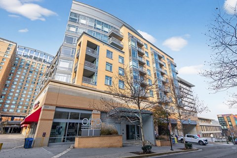 A modern building with a glass facade is situated in an urban area.