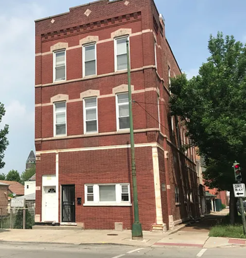 A red brick building with a white door and windows.