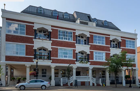 A red and white building with a car parked in front.