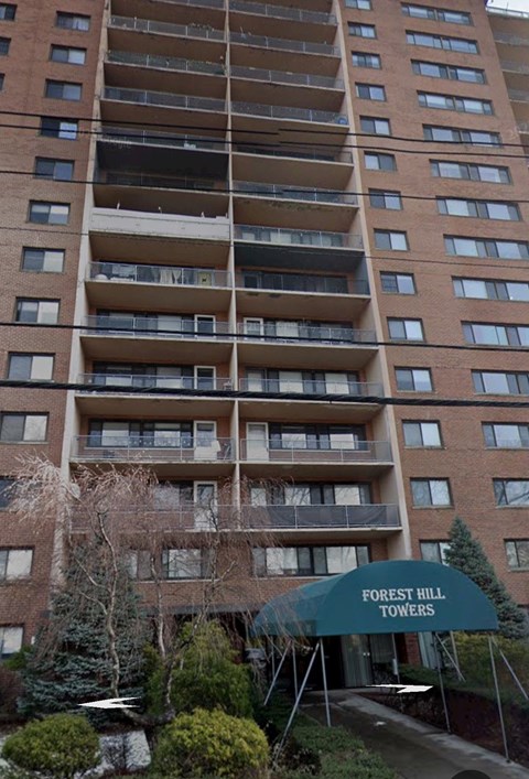 A tall building with balconies and a sign that says Forest Hill Towers.