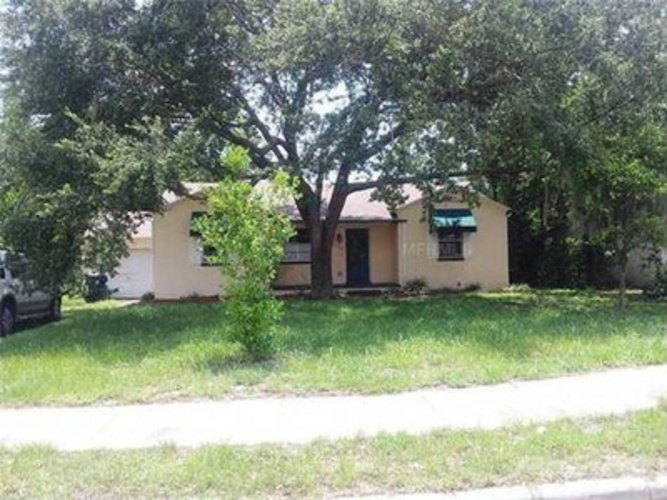 A house with a blue door is surrounded by trees.