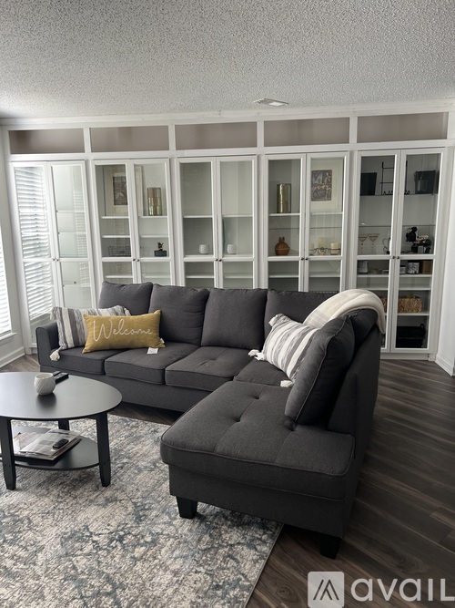 A living room with a grey couch and a coffee table.