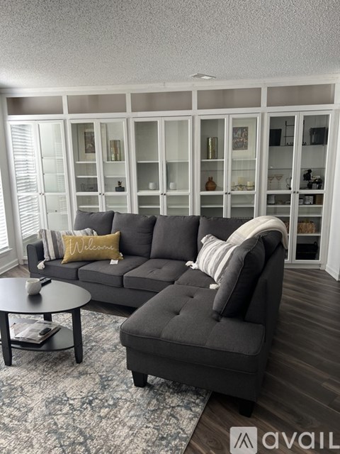 A living room with a grey couch and a coffee table.