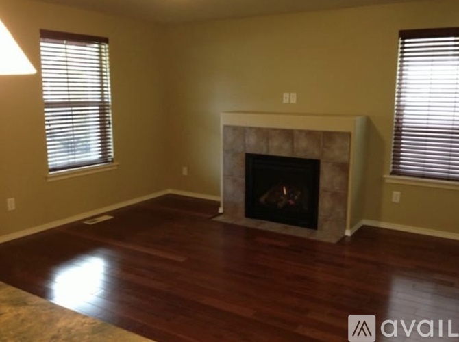 A living room with a fireplace and wood flooring.