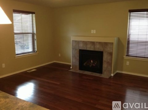 A living room with a fireplace and wood flooring.
