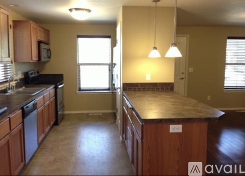 A kitchen with wooden cabinets and a black countertop.