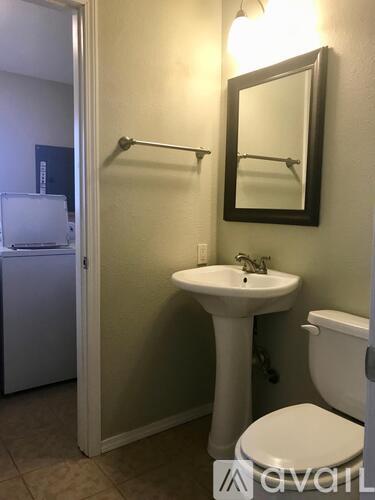 A bathroom with a sink, toilet and a mirror.