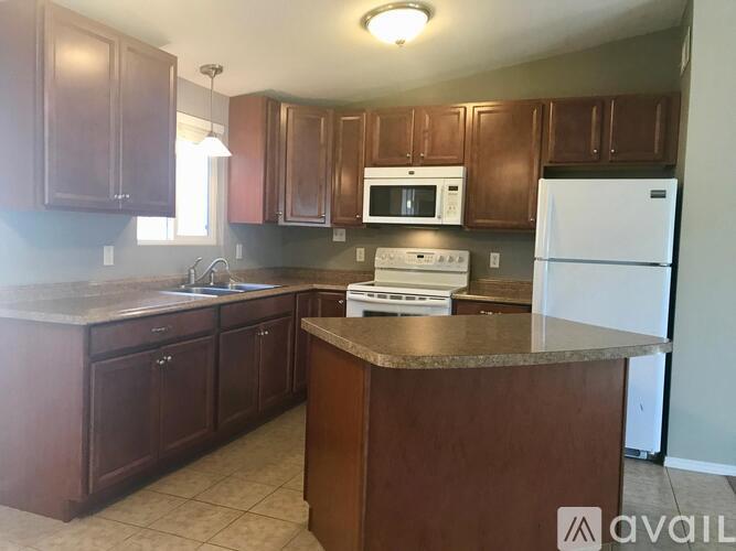A kitchen with brown cabinets and a white refrigerator.