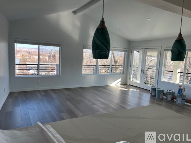 A room with wooden floors and large windows overlooking a snowy landscape.