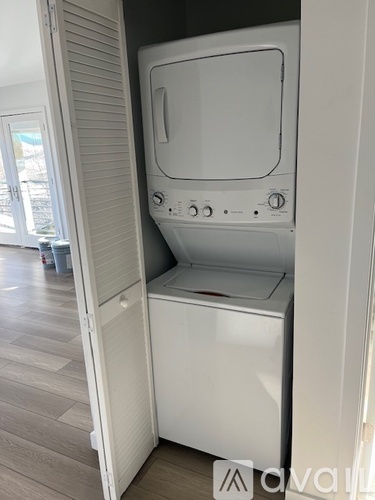 A white washing machine is sitting in a small space.
