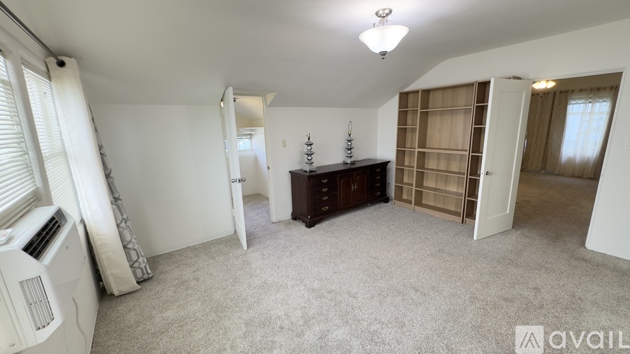 A living room with a carpeted floor and a television.