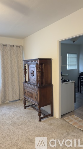 A kitchen with a stove, cabinets, and a window.