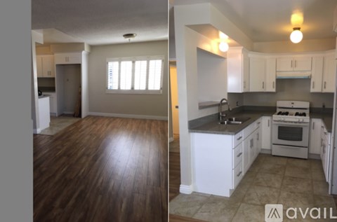 A kitchen with white cabinets and a black countertop.