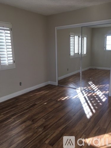 A room with wooden floors and a sliding glass door.