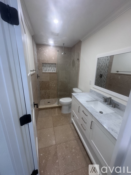 A bathroom with a toilet, sink, and shower.