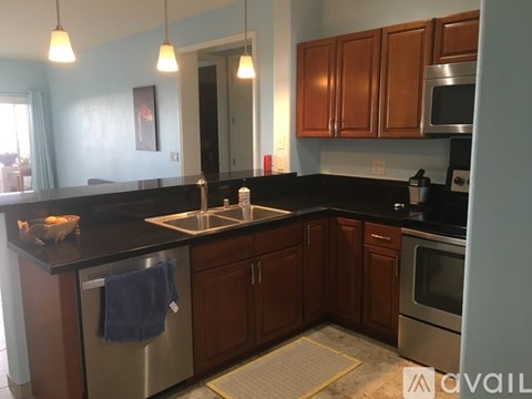 A kitchen with wooden cabinets and a black countertop.