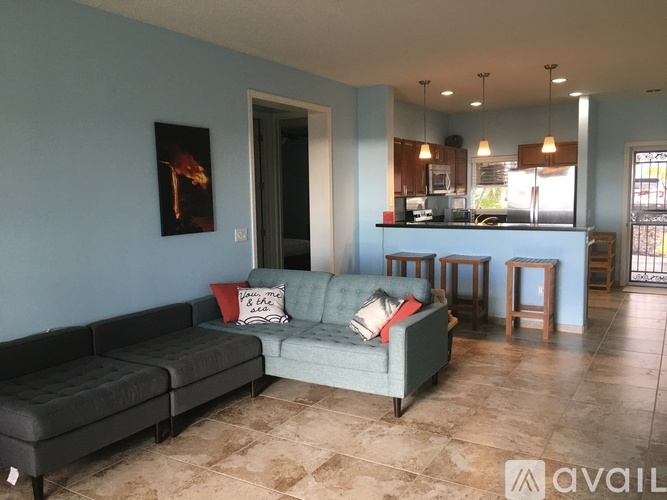 A living room with a couch and a painting on the wall.