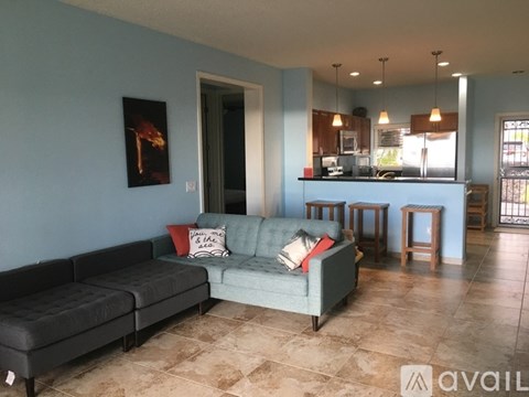 A living room with a couch and a painting on the wall.