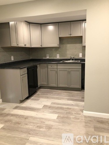 A kitchen with a black counter top and white cabinets.