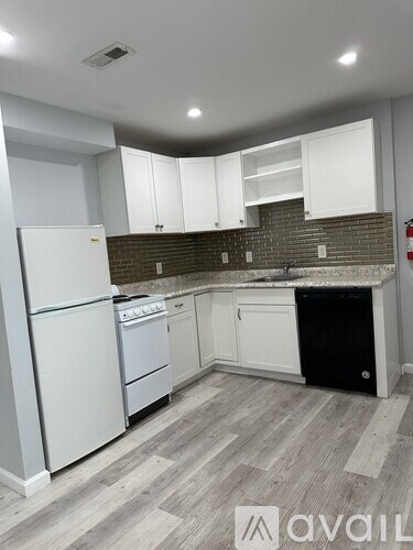 A kitchen with white appliances and cabinets.