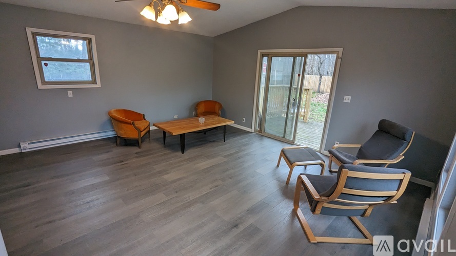 A living room with a grey wall and a window.
