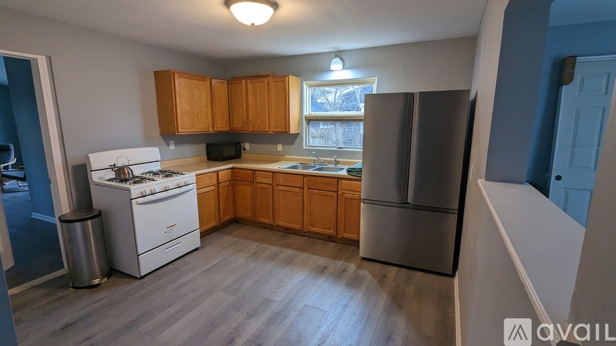 A kitchen with wooden cabinets and a stainless steel refrigerator.