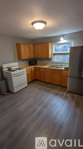 A kitchen with wooden cabinets and a white stove top oven.