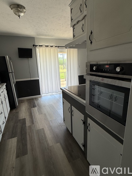 A kitchen with white cabinets and a black counter.
