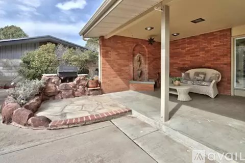 A house with a red brick exterior and a stone patio.