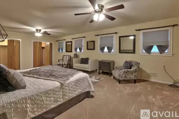 A bedroom with a large bed and a ceiling fan.