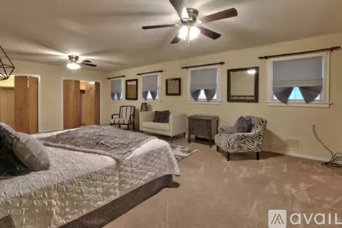 A bedroom with a large bed and a ceiling fan.