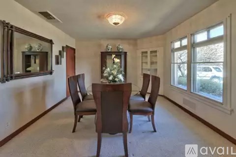 A dining room with a table and chairs.
