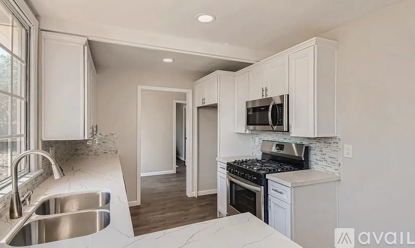 A kitchen with white cabinets and a stove top oven.