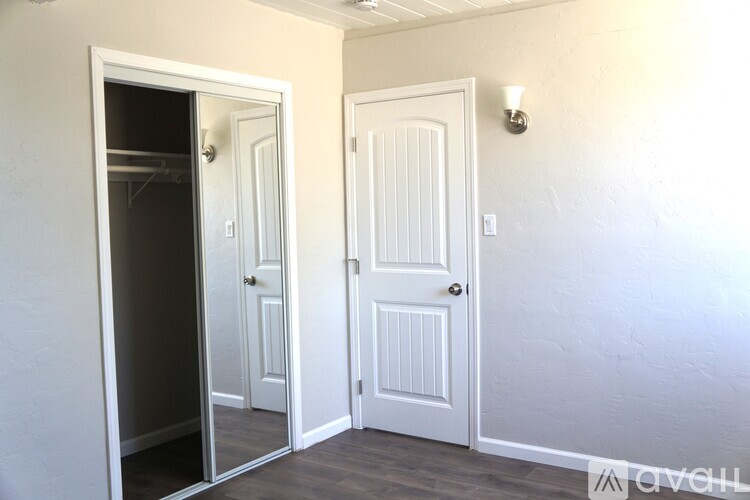 A white door is open to a dark hallway.