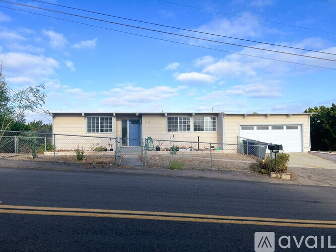 A building with a blue door and a garage door is available for rent.