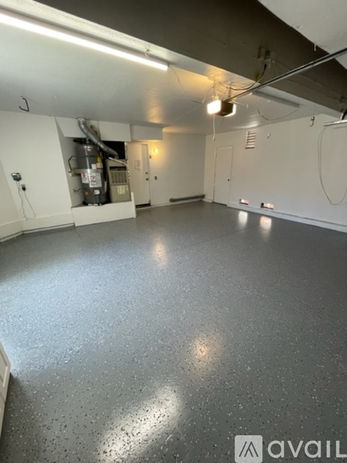 A spacious room with a concrete floor and white walls.