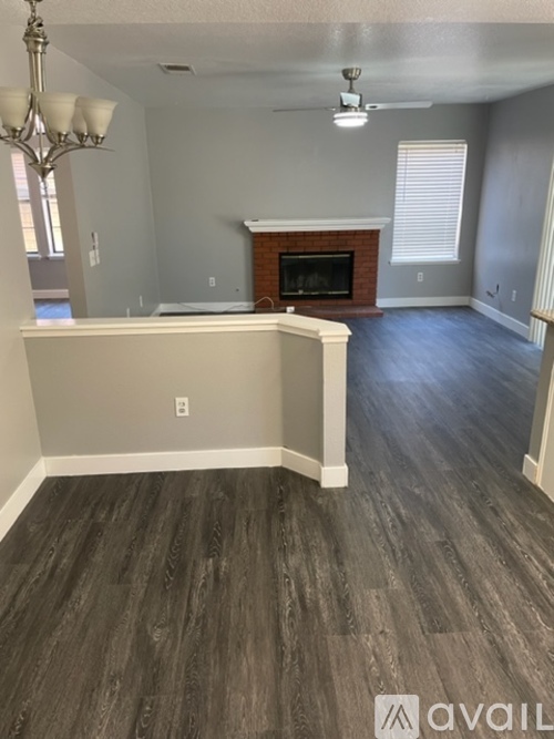 A living room with a fireplace and wood flooring.