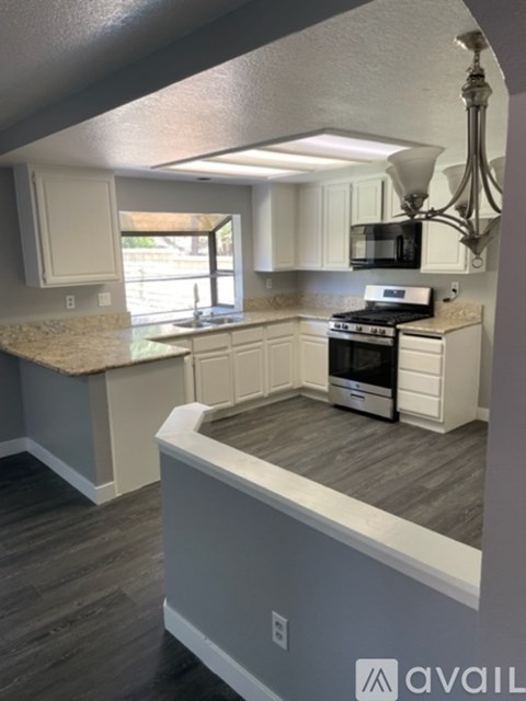A kitchen with a white stove top oven and a microwave above the stove.