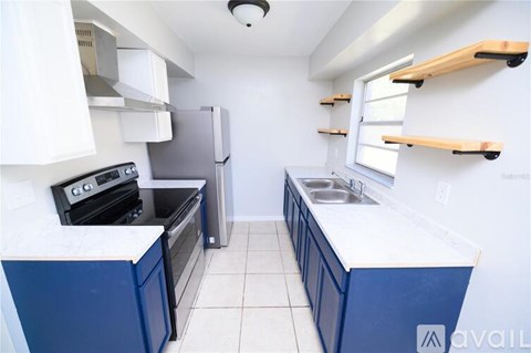 A kitchen with blue cabinets and white countertops.