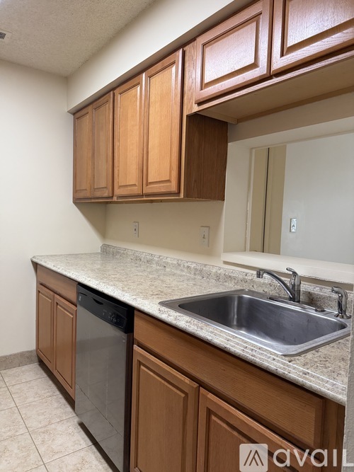 A kitchen with wooden cabinets and a granite countertop.