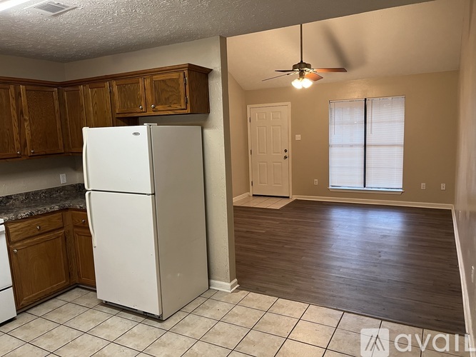 A kitchen with a white fridge and wooden cabinets.