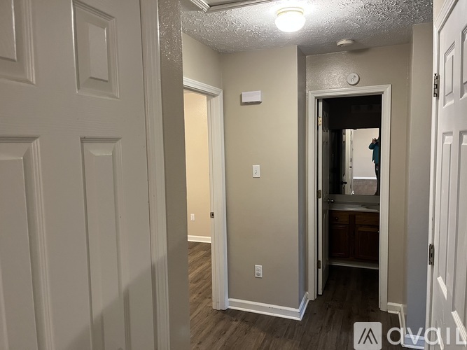 A hallway with a door on the right and a wall on the left.