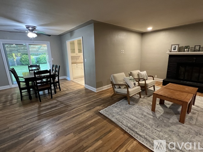 A living room with a fireplace and a dining table.