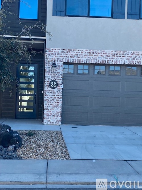 A house with a garage door and a number 32 on the wall.