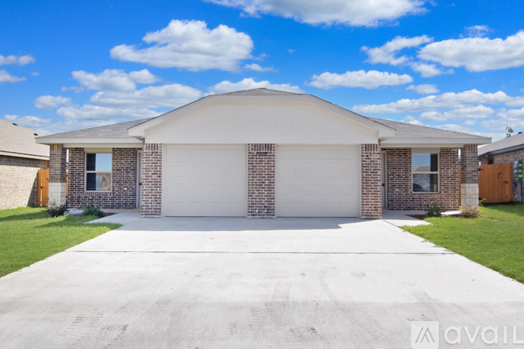 A two-story house with a garage door and a driveway.
