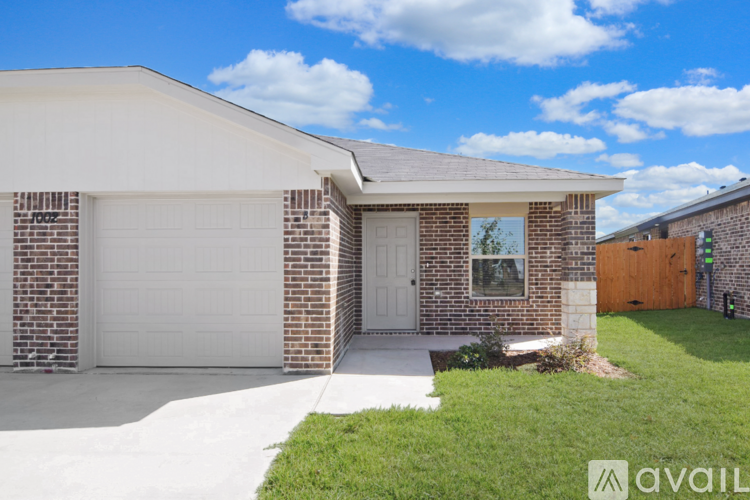A house with a white garage door and a brick wall.